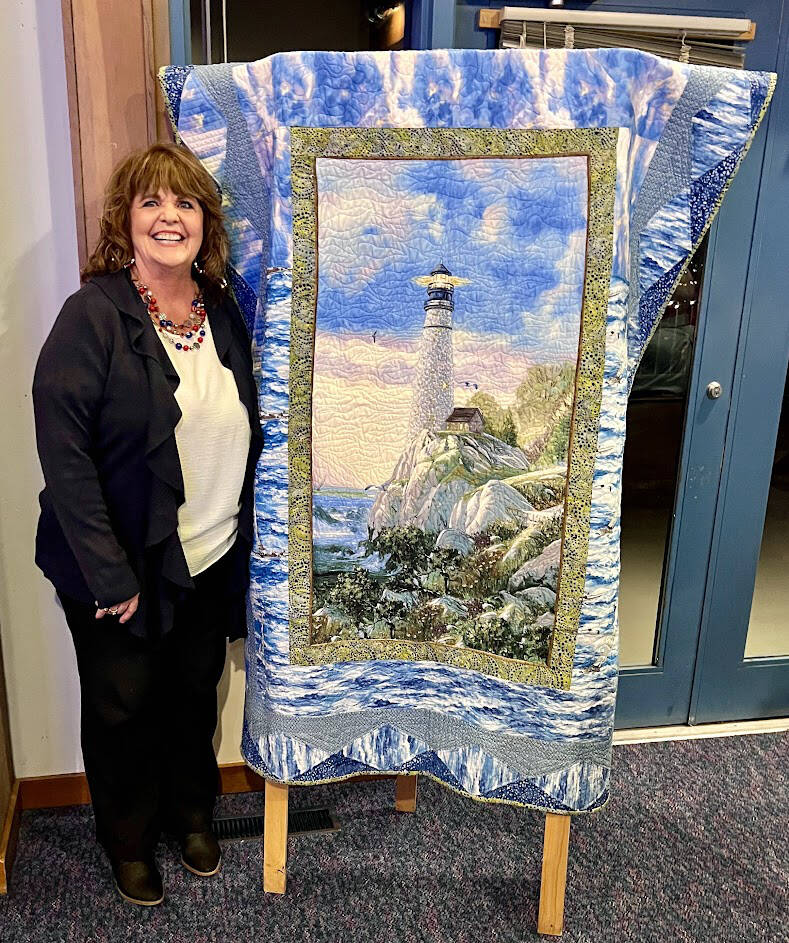 Photo by Doug Schwarz/For Sequim Bay Yacht Club 
Debbie Denton of Sequim is pictured with the quilt she won, a piece created by Sequim Bay Yacht Club members for a raffle prize that raised $1,610 for Volunteer Hospice of Clallam County.