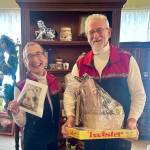 Photo courtesy of Renne Emiko Brock / Jim and Marlene Lewis of Sequim receive their Whodunnit Downtown? drawing gifts  from La Petite Maison Blanche, Over the Fence and Dungeness Kids Co.  on Jan. 5.