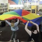 Photo courtesy of North Olympic Library System
Families play with a brightly colored parachute on Jan. 2 at Storytime in the Sequim Library.