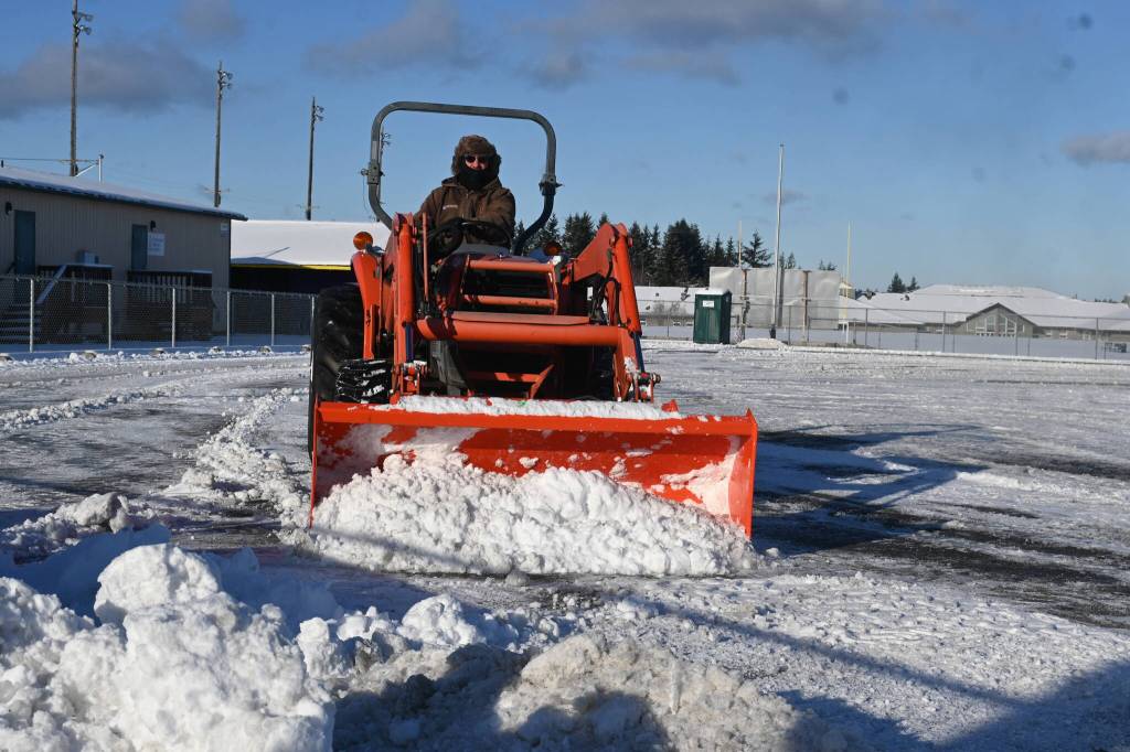 Sequim Gazette photo by Michael Dashiell / Dale Jung clears the Sequim School District stadium parking lot on jan 12, following a snowfall last week.