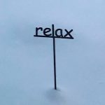 Photo by Janet Lenfant/ As snow covers its base, this sign encourages people to relax.