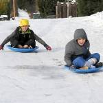 Photo by Keith Thorpe/Olympic Peninsula News Group / Cameron Torres, 8, left, and his brother, Steven Torres, 9, slide their way down a frozen alley behind their home near 11th and C streets in Port Angeles on Jan. 13. The youngsters braved temperatures in the 20s and wind chills in the teens in pursuit of some gravity-assisted entertainment.