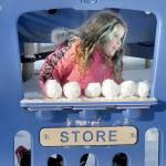 Photo by Keith Thorpe/Olympic Peninsula News Group / Madrona Villella, 7, of Port Angeles looks out from a pretend storefront lined with snowballs at the childrens playground at Shane Park on Jan. 12 in Port Angeles. The youngster braved single-digit wind chills for a chance at a snow day in the park.