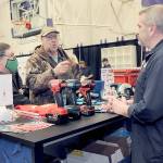 Jack and Marcella Ridge of Sequim talk about power tools with Tony Contestable, tool specialist with Hartnagel Building Supply of Port Angeles, right, during Saturday's 2023 Building, Remodeling & Energy Expo in the Sequim High School gym. The two-day event, hosted by the North Peninsula Building Association, featured a variety of booths, displays and presentations dedicated to home building, repair and remodeling. (Keith Thorpe/Peninsula Daily News)