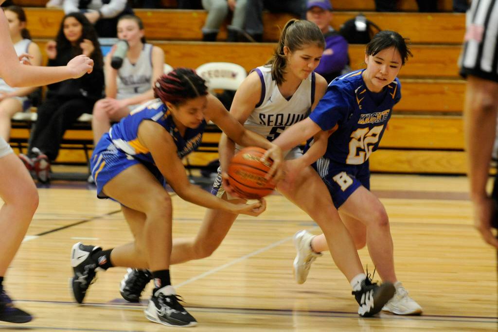 Sequim Gazette photo by Matthew Nash / Sequims Raimey Brewer, center, tries to keep the ball from a pair of Bremerton defenders in a 70-41 Sequim home win on Jan. 19.