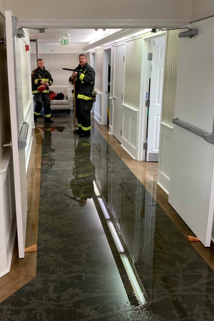 Photo courtesy Clallam County Fire District 3
Clallam County Fire District 3 firefighters help clean up water at Dungeness Courte Memory Care on Jan. 14 after a sprinkler head broke due to cold weather. No residents were impacted, staff and the fire district reported.