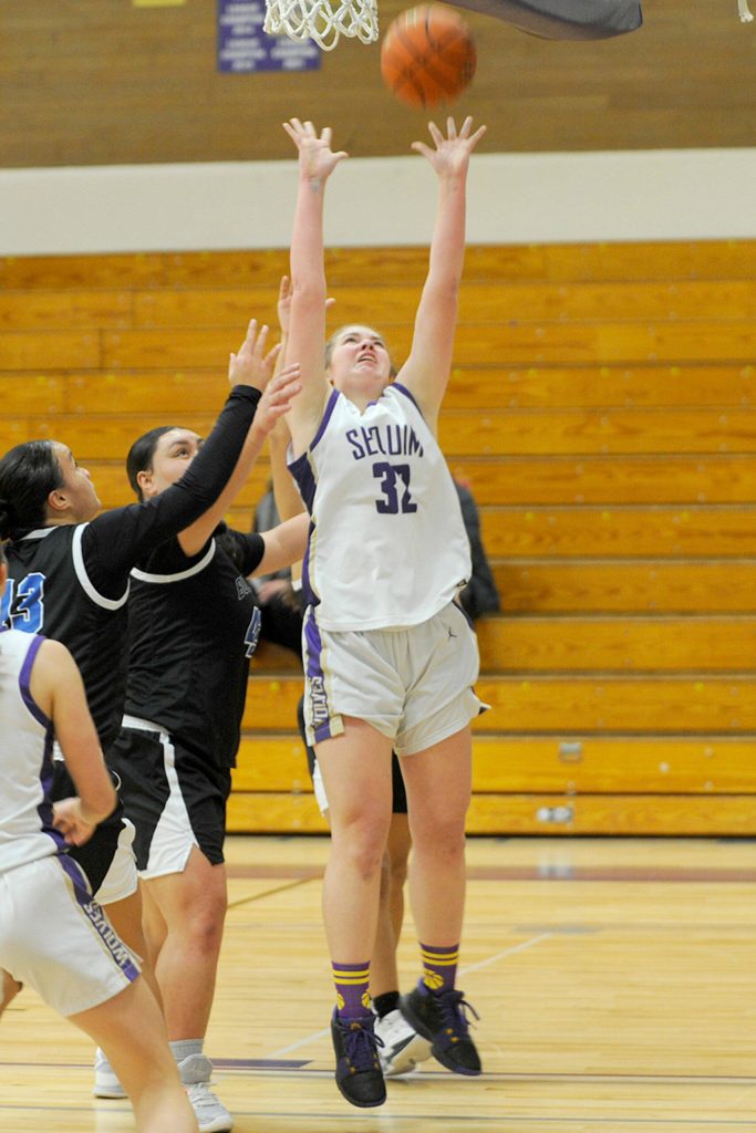 Sequim Gazette photo by Matthew Nash/ Hailey Wagner snags a rebound over North Mason players on Jan. 26.