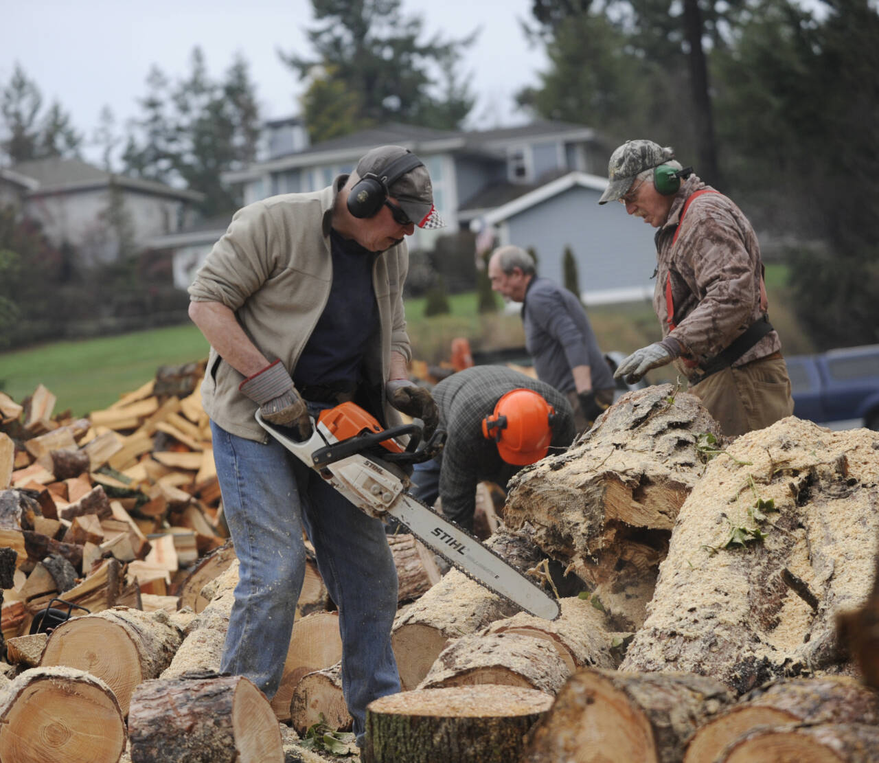 Sequim Gazette photo by Michael Dashiell / From left, Dan Kalinski, Jack Tatom, Ron Long and Wally Jenkins in January cut, chop and split wood for cords, whose sales go directly to help the Path From Poverty nonprofit.
