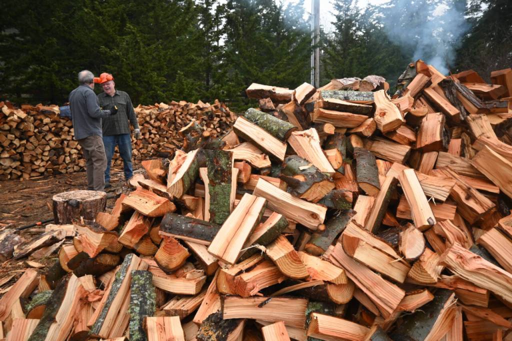 Sequim Gazette photo by Michael Dashiell / Ron Long, left, and Jack Tatom chat in a rare break between cutting wood for their groups efforts to help the Path From Poverty nonprofit.
