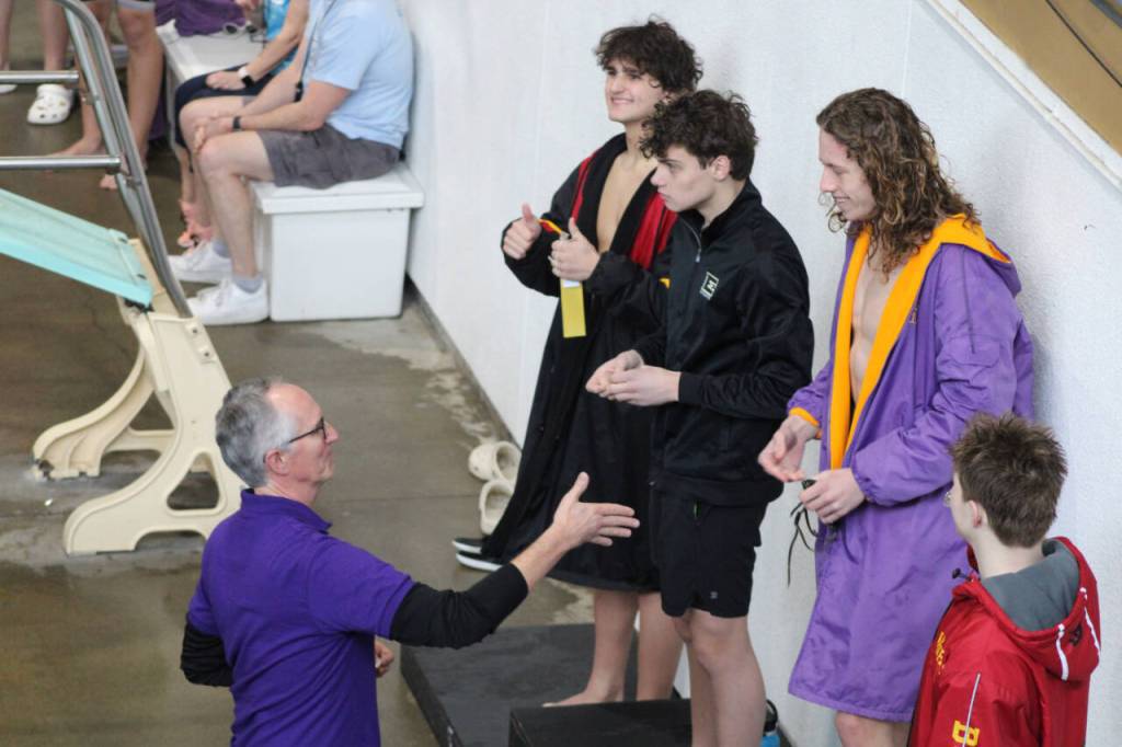 Photo by Eric Ellefson / Sequim's Colby Ellefson, right, is congratulated by Sequim swimming coach Britt Hemphill after winning the 200-yard freestyle at the West Central District meet in Renton last week.