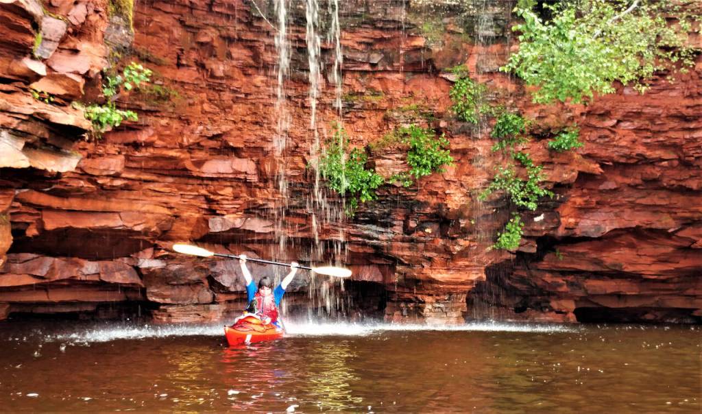 Photo courtesy of Gail Green and Grant Herman / A kayaker enjoys a waterfall off one of the Apostle Islands.