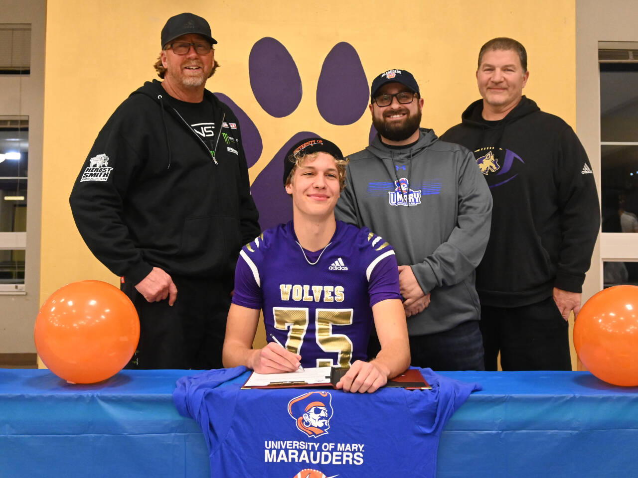 Sequim Gazette photo by Michael Dashiell
Sequims Jack Henninger on Feb. 7 signs a letter of intent to play at the University of Mary (North Dakota). The all-Olympic League kicker plans to study occupational therapy and kick for the Marauders football squad. Behind him are, from left, soccer coach David Breckenridge, football special teams coach Cody Buckmaster and football head coach Erik Wiker.