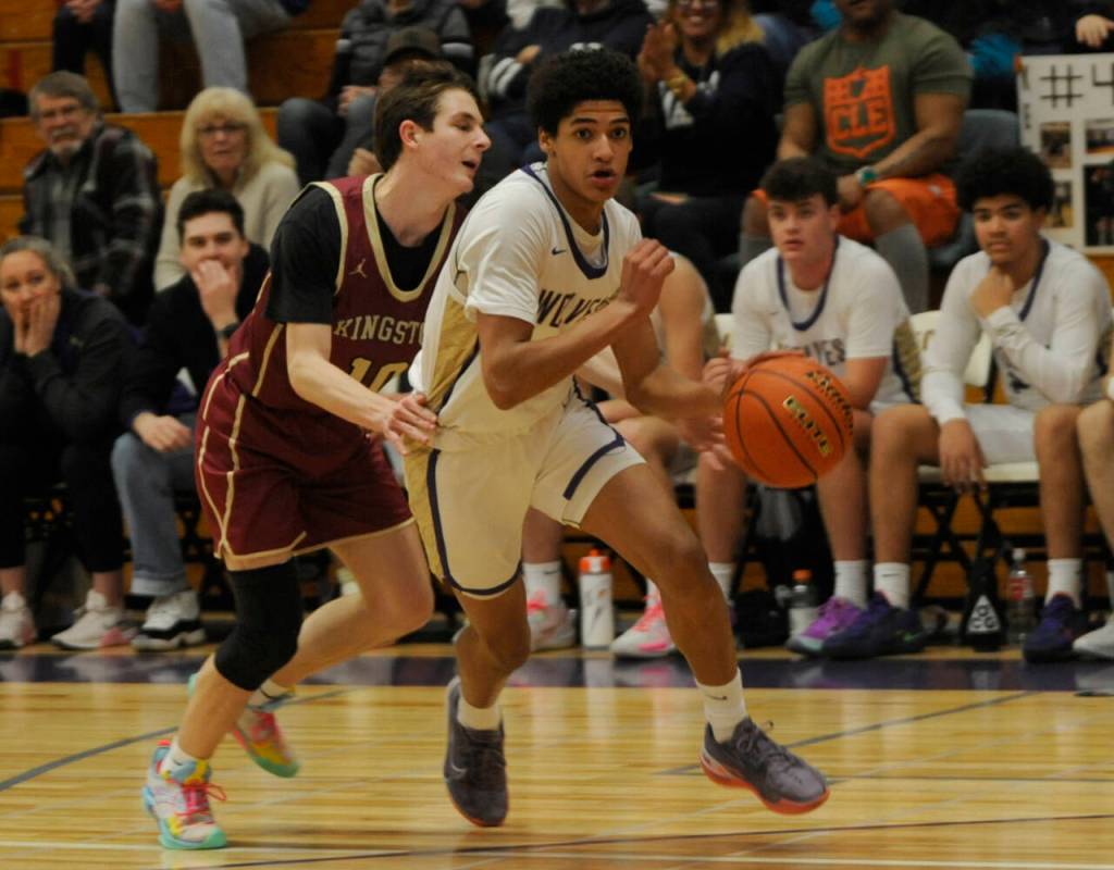Sequim Gazette photo by Michael Dashiell / Sequim's Solomon Sheppard, right, looks to drive past Kingston's Ibrahim Trawally in the fourth quarter of a 63-50 Wolves win on Jan. 26.