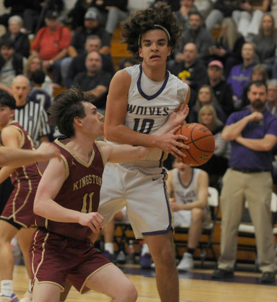 Sequim Gazette photo by Michael Dashiell / With Sequim coach Craig Brooks, right, looking on, Sequim's Lars Wiker snags an offensive rebound as Kingston's Dewaun Swan (11) guards the play in the Wolves' 63-50 win over the Buccaneers on Jan. 26.