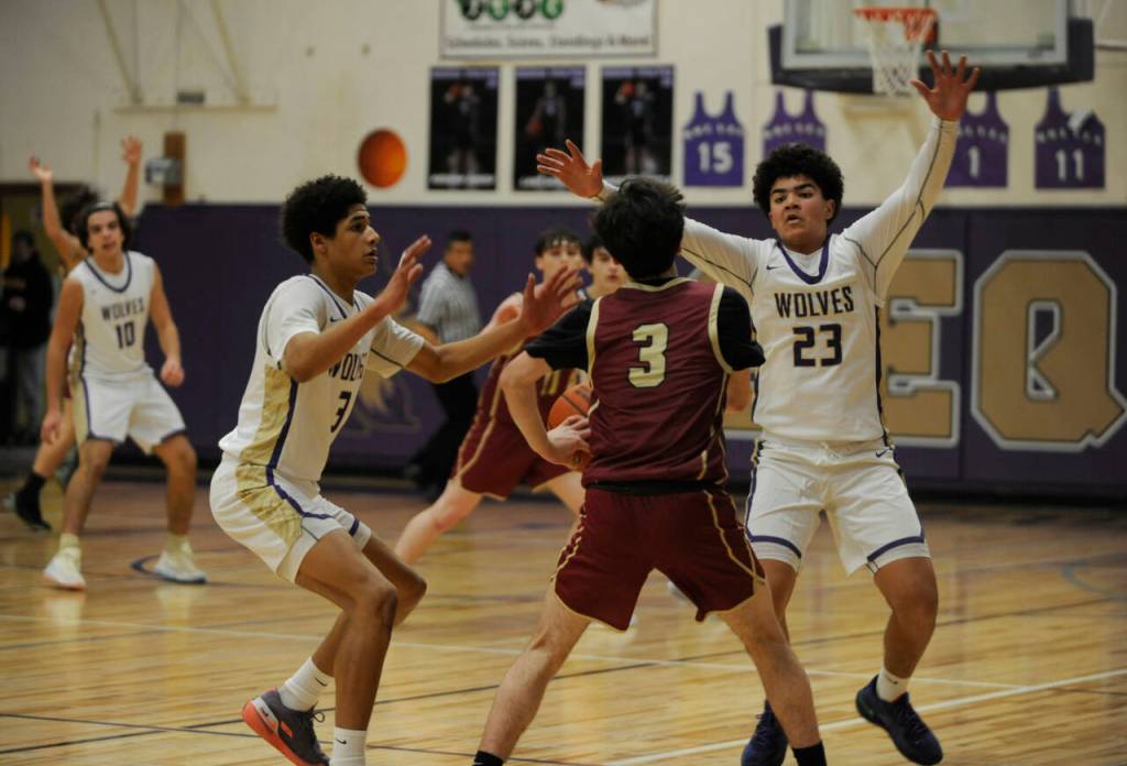 Sequim Gazette photo by Michael Dashiell / Sequim's Solomon Sheppard, left, and Jericho Julmist, right guard Kingston's Jace Brady in a 63-50 Wolves win on Jan. 26.