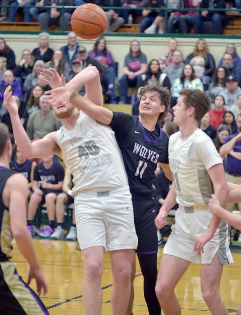 Photo by Keith Thorpe/Olympic Peninsula News Group
Sequims Charlie Grider, center, fights for a rebound with Port Angeles Isaiah Shamp, left, as Port Angeles Dallas Dunning looks on during the teams Olympic League finale in Port Angeles on Feb. 6.