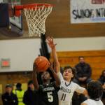 Sequim Gazette photo by Michael Dashiell
Sequims Charlie Grider, right, blocks a shot by Evergreens Mohamed Abdi in the second half of the Wolves 73-61 bi-district tournament win in Sequim on Feb. 13.