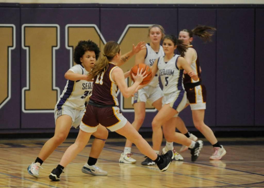 Sequim Gazette photo by Michael Dashiell / Sequims Bobbi Mixon, left, guards Sydney VanHoof as SHS teammate Raimey Brewer looks on in a bi-district tournament game on Feb. 14 in Sequim.