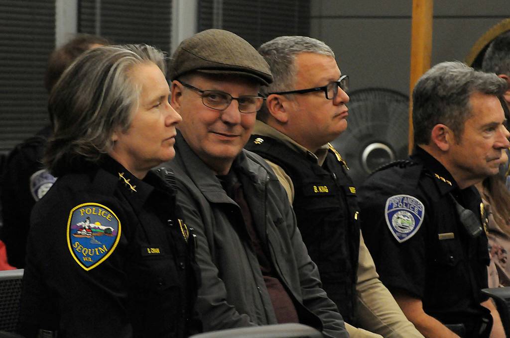 Sequim Gazette photo by Matthew Nash/ Sequim Police Chief Sheri Crain listens to a proclamation at the Feb. 26 Sequim city council meeting as her husband Pat looks on during the ceremony.