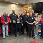 Sequim Gazette photo by Matthew Nash/ First responders stand with Sequim police chief Sheri Crain after a proclamation was read at the Feb. 26 city council meeting honoring her service in the city.