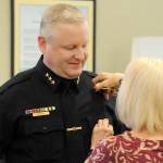 Sequim Gazette photo by Matthew Nash
Kathy Gresli pins the Sequim Police Chief badge on her son Mike Hill on March 1 inside the Sequim City Council chambers. Hill said his dad pinned his first officer badge on him in 2001 when he was hired in Sequim full-time.