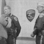 Sequim Gazette file photo by Michael Dashiell / Mike Hill receives a pin from his father after being sworn in as a full-time officer in early August 2001. The 24-year-old had served as a reserve officer for three years. Looking on is then Sequim Police chief Byron Nelson.