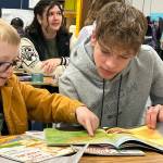 Helen Haller Elementary third grader Patrick Dorgan and Sequim High freshman Bjorn Henrikson search through a good book for Sequim School Districts celebration of Read Across America Day.