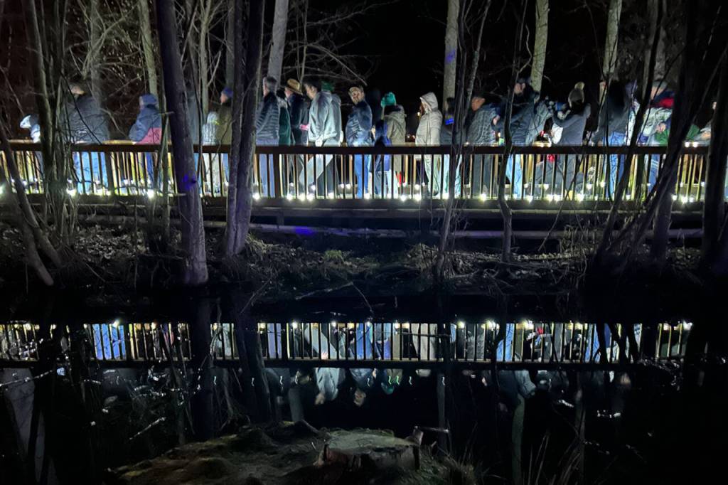 Sequim Gazette photo by Matthew Nash/ Visitors of the Sequim Sunshine Festival exit Carrie Blake Community Park via bridge after the illuminated drone show on March 2.