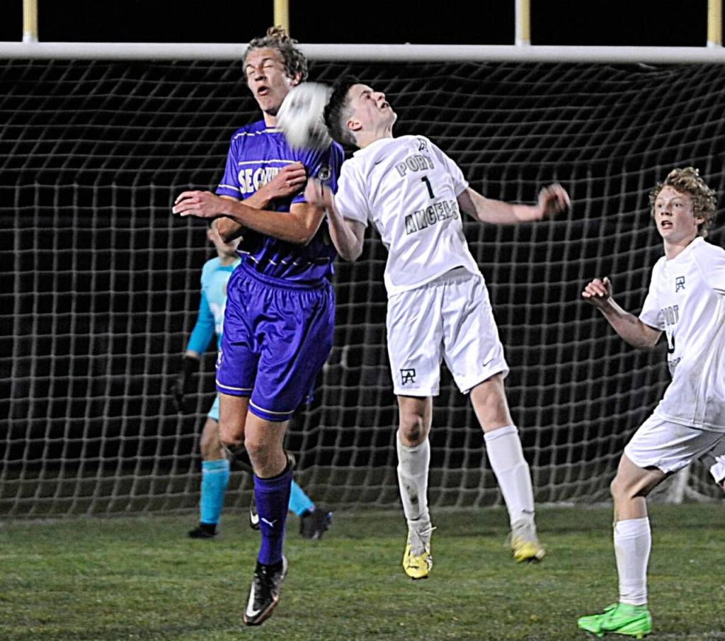 Sequim Gazette photo by Matthew Nash / Sequims Jack Henninger, left, and Port Angeles Daniel Blondolillo vie for the ball in the Wolves season-opening 4-2 win over PA on March 14.