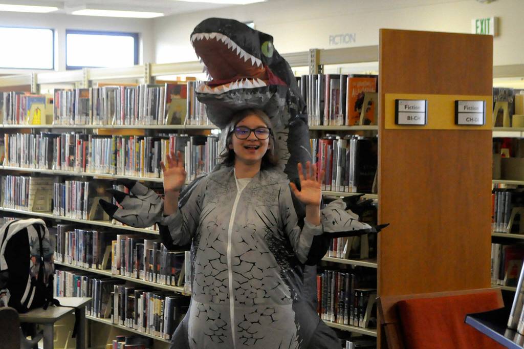 Sequim Gazette photo by Matthew Nash/ Abigail West, 14, dresses as a T-Rex for the librarys send-off celebration before its renovated and expanded over the next year. Itll reopen at a temporary space in the former Brians Sporting Goods on April 1. West said she comes to the library for Teen Night and her costume was following her moms motif that its free to have a good time.