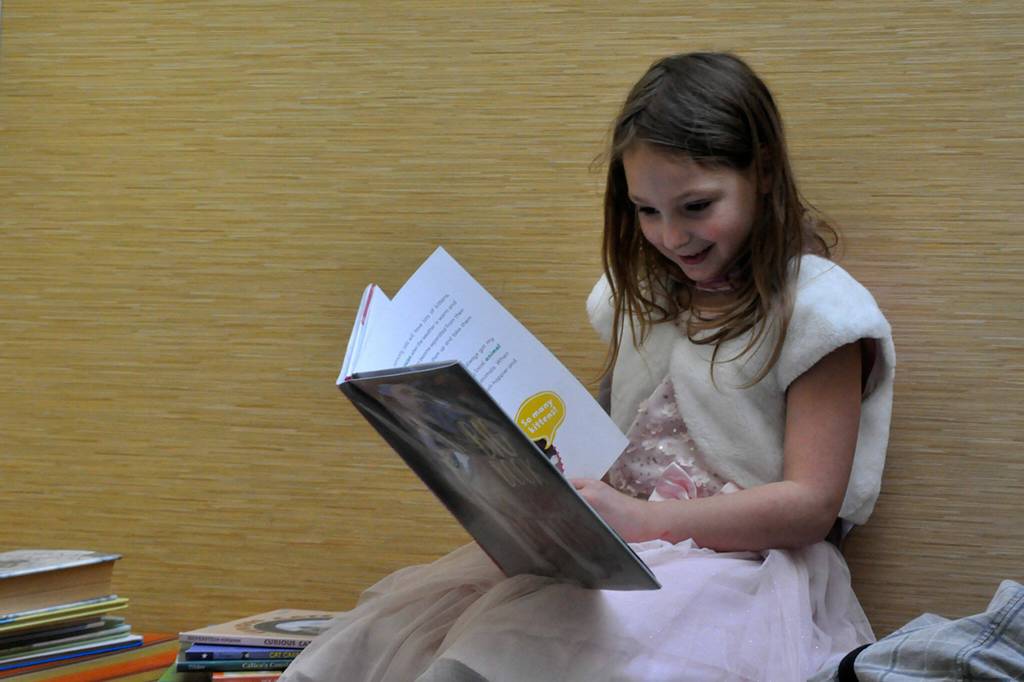 Sequim Gazette photo by Matthew Nash/ Anna-Marie Tax, 7, reads a book about cats as part of a 4-H project shes doing. She wanted to visit the Sequim Library on March 9 before it closed temporarily for three weeks.