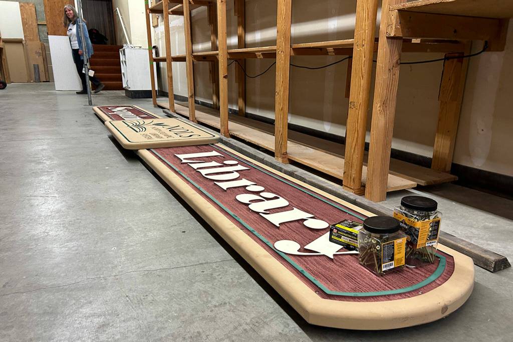 Sequim Gazette photo by Matthew Nash/ The Sequim Library sign is one of the last things to be placed before materials move from the Sequim Avenue library to the temporary space on Washington Street next to the former JCPenney building. The temporary library will be open through expansion and renovation of the existing library.