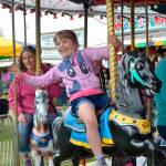 Sequim Gazette file photo by Matthew Nash
The Sequim Irrigation Festival last held its carnival in 2019 offering rides, such as the Merry-Go-Round, pictured here with Alyssa LAmi waving, and her mom Riki on the right. The COVID-19 pandemic and lack of available carnival companies due to workforce shortages has led festival organizers to extend Family Fun Days to two days May 4-5, 2024.