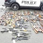 Photo courtesy of Everett Police Department / Returned lost or stolen firearms recovered by the Everett Police Department are laid out in a parking lot. The department started a program to get guns off the street called guns for giftcards.