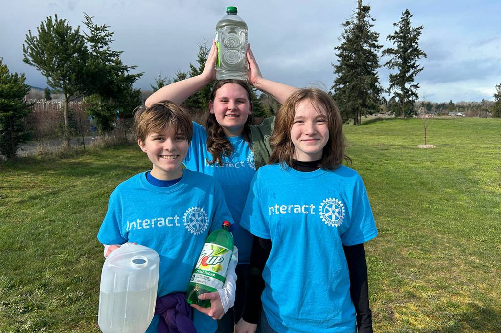 Sequim Gazette photo by Matthew Nash/ Interact Club members, from left, Zee French, London Forrest, and Kaitlyn Carpenter carry containers during the Walk for Water event on March 9 from the Dungeness River to Sequim Middle School. Students carry water as part of a fundraiser to build a well for a school in Africa.