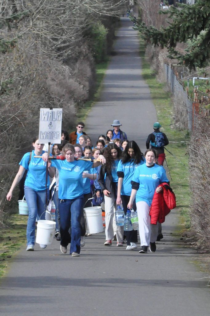 Sequim Gazette photo by Matthew Nash
Sequim High Schools Interact Club members along with a few Sequim Sunrise Rotary members walk along the Olympic Discovery Trail on March 9 for their annual Walk for Water event. They carry water from the Dungeness River to Sequim Middle School to symbolize the journey people take daily for clean water.