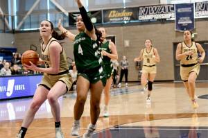 Peninsula College's Alexa Mackey goes to the rim up against Umpqua's Amaya Afatasi (4) on Saturday in Pasco. Trailing the play are Peninsula's Jenilee Donovan (11) and Shania Moananu (24). Umpqua won 73-55.(Jay Cline/Peninsula College)