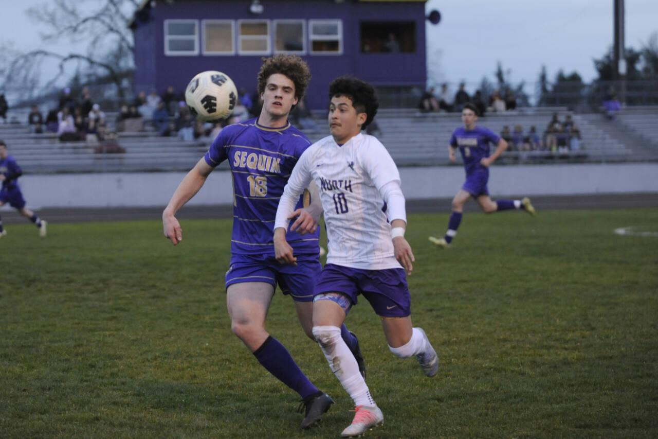 Sequim Gazette photo by Michael Dashiell / Sequims Sam Stewart, left, battles North Kitsaps Pepe Deluna for possession in the Wolves 4-0 home loss to NKs Vikings on March 21.