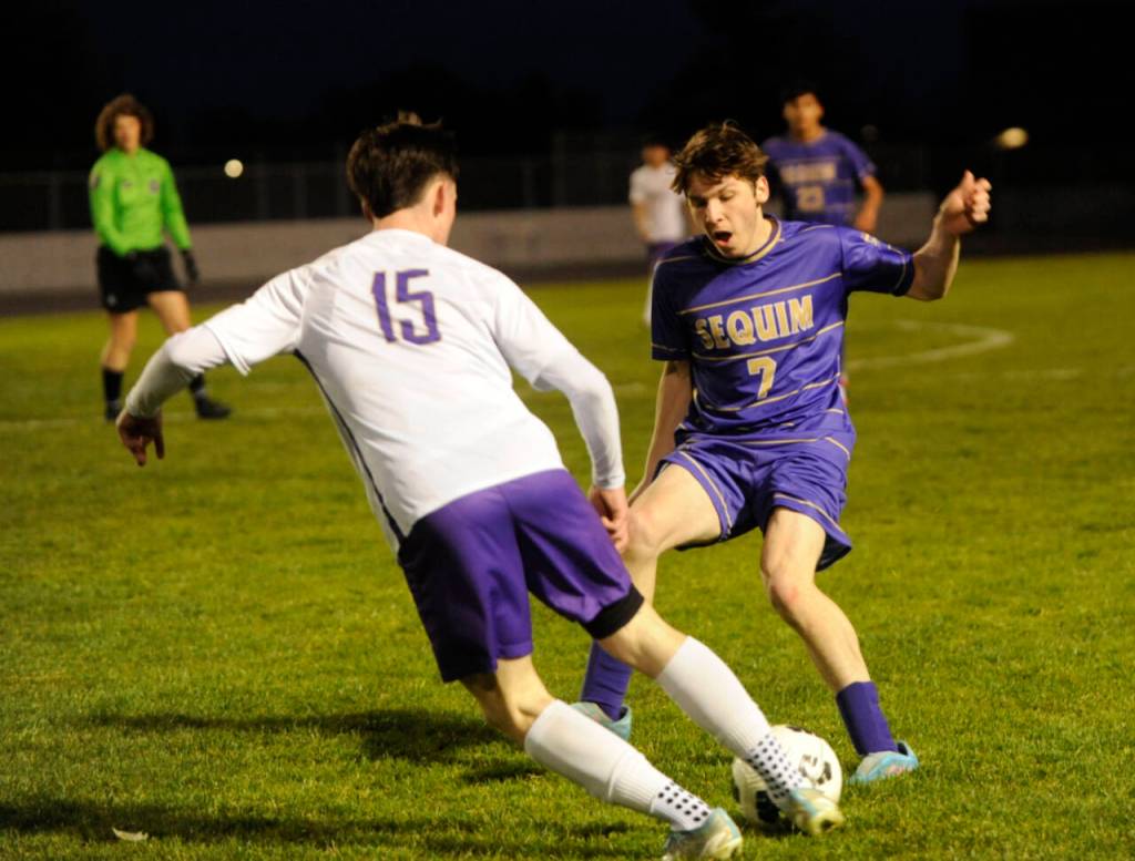 Sequim Gazette photo by Michael Dashiell / Sequims Parker Knight, right, looks to impede the progress of North Kitsaps Logan Anderson in a March 21 Olympic League match-up.