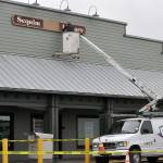Sequim Gazette photo by Matthew Nash/ Bruce Miller, owner of Miller Signs, places the Sequim Library sign on March 22 outside the temporary building at 609 W. Washington St., Suite 21. Miller Signs former owner Rob Campbell built the sign in 2009 for the remodel of the current library at 630 N. Sequim Ave. The library is set for expansion and renovation through the next year.