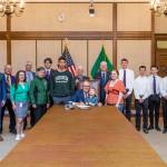 Photo courtesy of Randy Tomaras/Gov. Jay Inslees office
Gov. Jay Inslee, center, signs Substitute Senate Bill No. 5687 in April 2023  legislation called the Charles Cate II Act, that bolsters the creation and support of postsecondary wrestling grant programs. Joining Inslee are Cates son Charley and wife Renee. Behind Inslee is primary bill sponsor Sen. Kevin Van De Wege and Sequim wrestling advocate Randall Tomaras, along with wrestlers and other wrestling advocates.