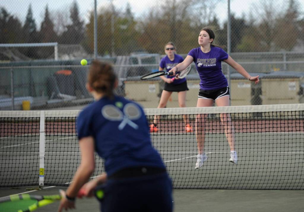 Sequim Gazette photo by Michael Dashiell / Sequims Kendall Day, right, returns a shot as she and doubles partner Payton Smithson take on Bainbridges Cece Combs and Xin Munson in an Olympic League match on April 9 in Sequim.