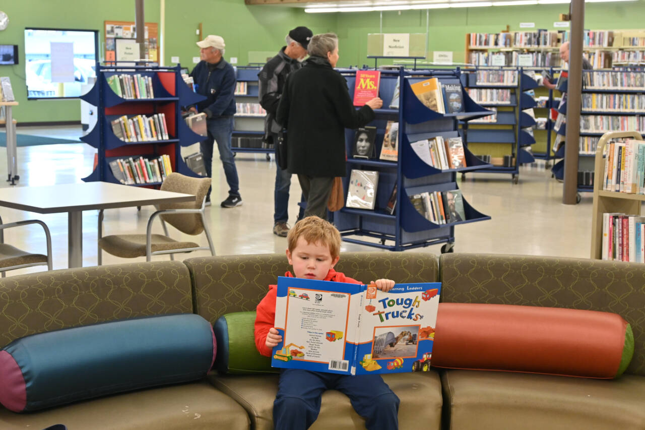 Sequim Gazette photo by Michael Dashiell / Francis Ward, 4, of Sequim, digs into a book at the opening of the Sequim Librarys temporary location on April 1.