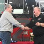 Sequim Gazette photo by Michael Dashiell / Outgoing Fire District 3 chief Ben Andrews is congratulated by current District3 chief Justin Grider at a March 27 ceremony in Sequim.
