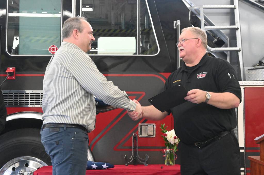 Sequim Gazette photo by Michael Dashiell / Outgoing Fire District 3 chief Ben Andrews is congratulated by current District3 chief Justin Grider at a March 27 ceremony in Sequim.