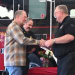 Sequim Gazette photo by Michael Dashiell / Outgoing District 3 interim chief Dan Orr gets a hearty thanks from current chief Justin Grider; deputy chief Tony Hudson is in the background.