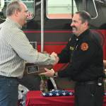 Sequim Gazette photo by Michael Dashiell / Outgoing Fire District 3 chief Ben Andrews gets some honors and a thank-you from deputy chief Tony Hudson at a March 27 ceremony.