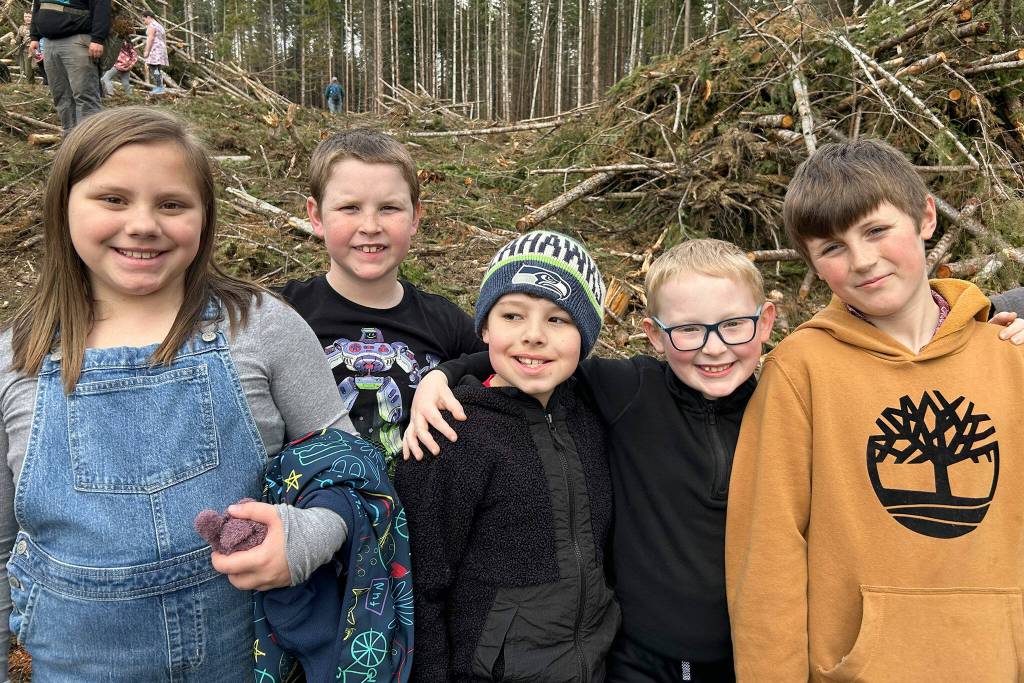 Sequim Gazette photo by Matthew Nash/ Presley Joslyn-Bland, Greylan Galloway, Malcom Hansen, Oliver Nash and Levi Rickard gather for a photo after planting several trees during a field trip.