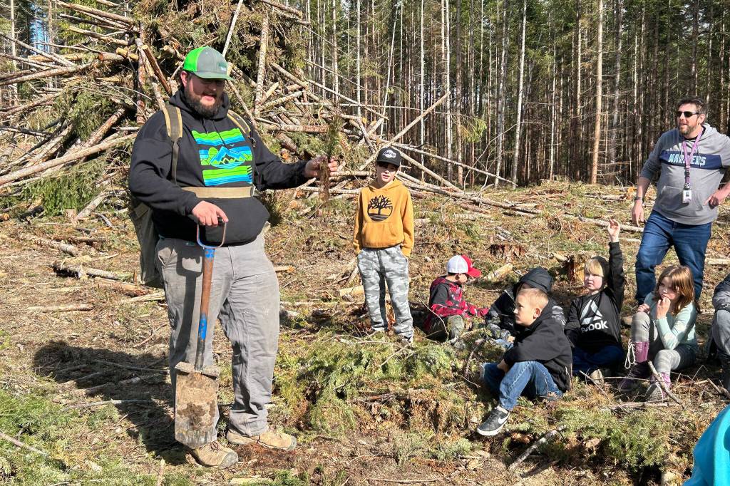 Sequim Gazette photo by Matthew Nash/ Volunteer Connor Heilman talks with students on March 29 about best practices for planting trees during a field trip.