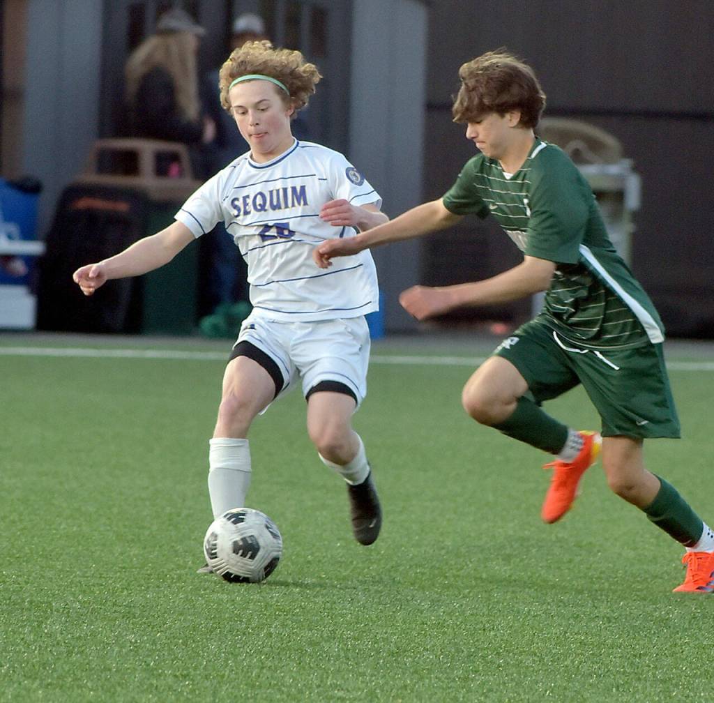 Photo by Keith Thorpe/Olympic Peninsula News Group / Sequims Max Stanford, left, dribbeles past Port Angeles Aurelio Wilson-Rojero on April 16 in Port Angeles.